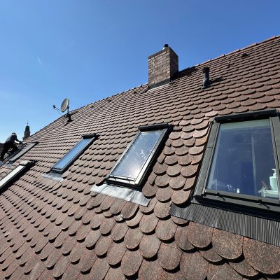Traditional tiled roof restoration with multiple windows
